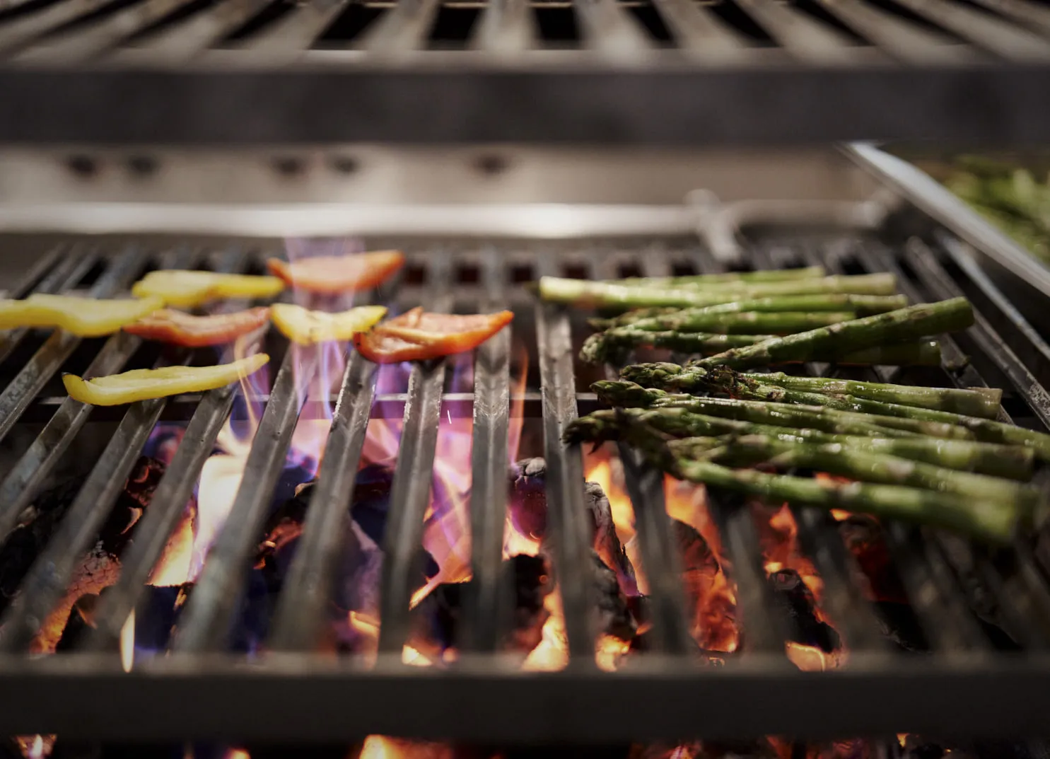 Gemüse grillt auf einem Rost über offenen Flammen