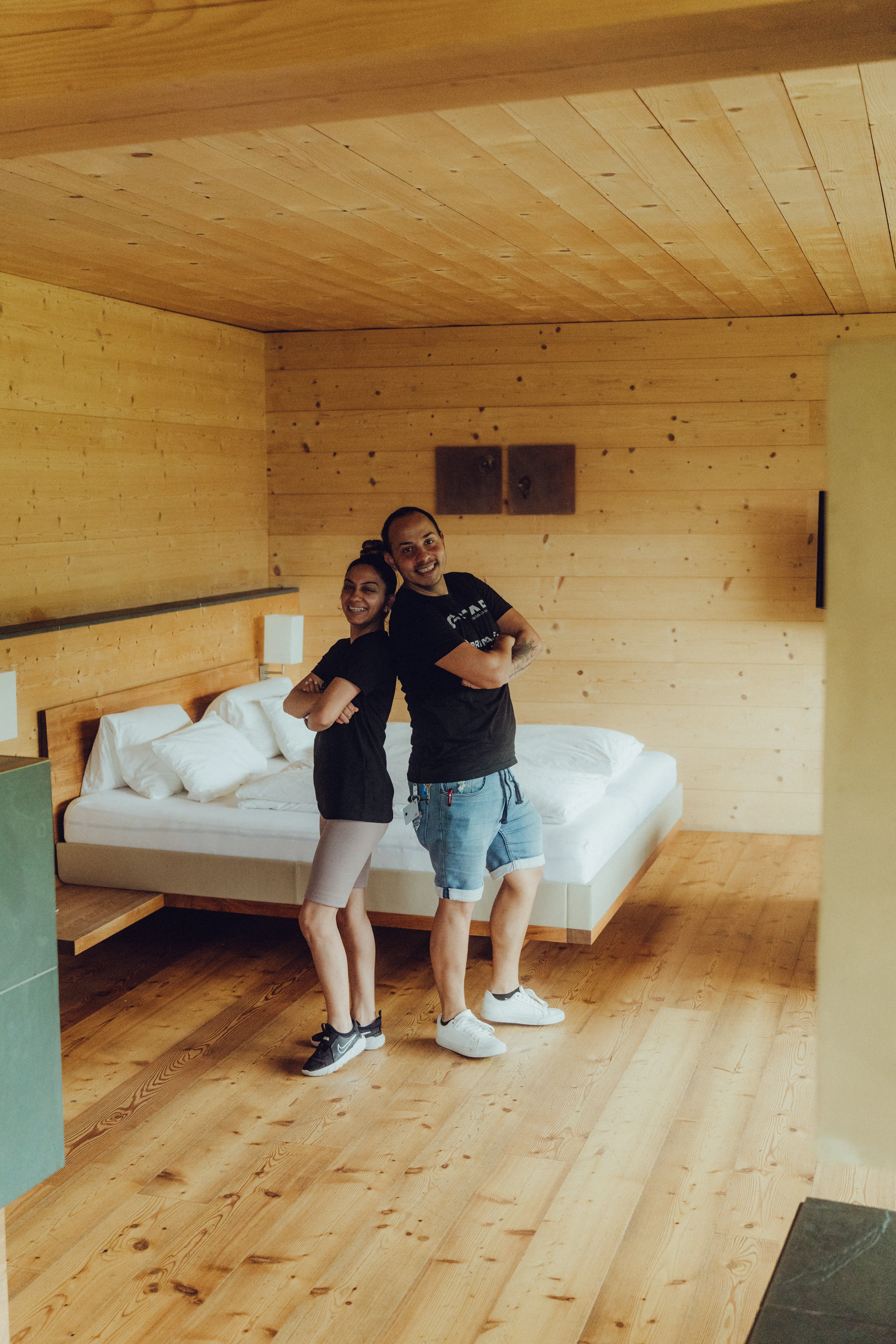 Paar posiert in modernem Holzraum mit Bett